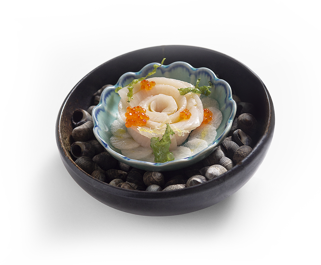 black plate with black shells and a fish in the middle