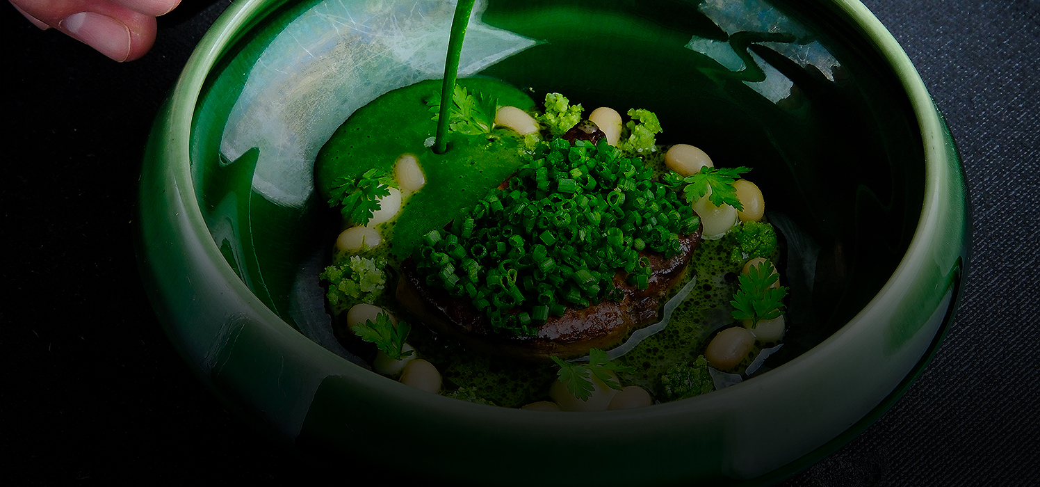 green plate with some vegetables and green sauce inside